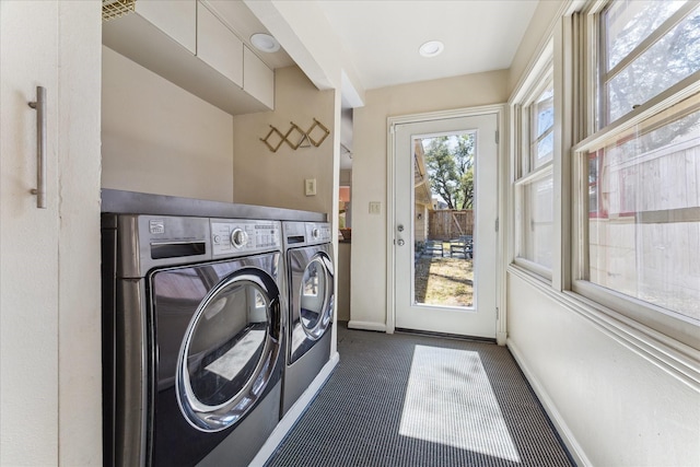 washroom featuring laundry area, baseboards, independent washer and dryer, and dark carpet