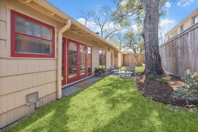 view of yard featuring a patio area, french doors, and fence