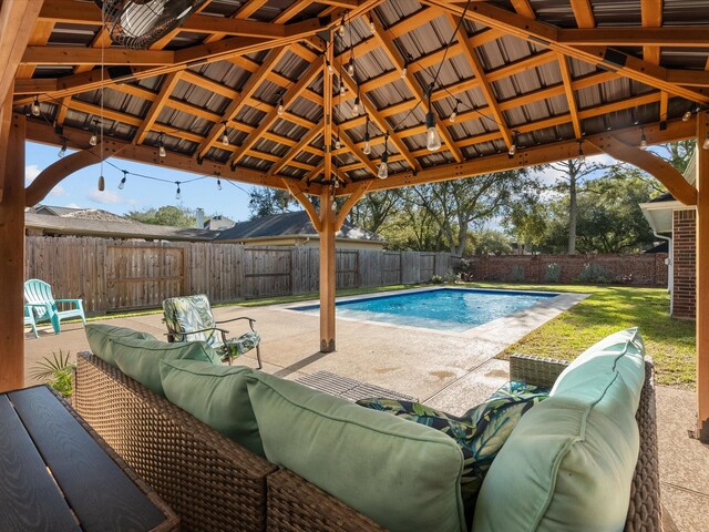 view of pool with an outdoor living space, a patio, a fenced backyard, a gazebo, and a fenced in pool