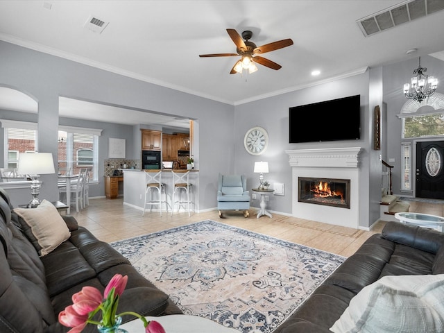 living area with a glass covered fireplace, light tile patterned flooring, visible vents, and ceiling fan