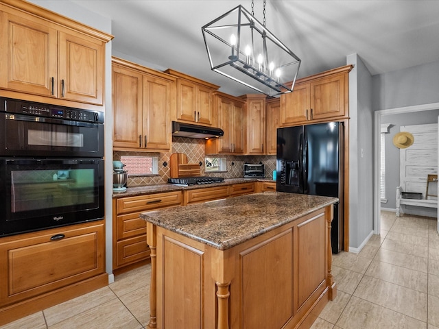 kitchen featuring tasteful backsplash, a center island, under cabinet range hood, an inviting chandelier, and black appliances