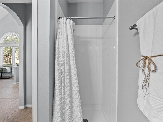 full bath featuring a shower stall and baseboards