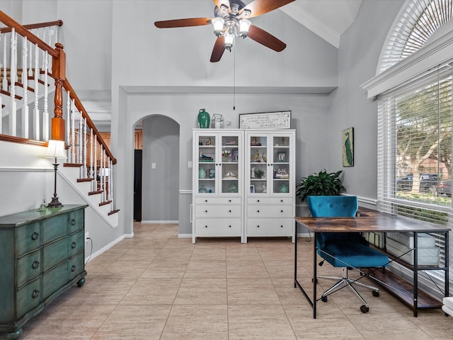 office area with high vaulted ceiling, a ceiling fan, arched walkways, light tile patterned floors, and baseboards