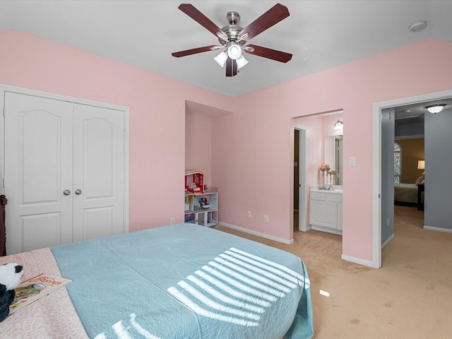 bedroom featuring light carpet, a ceiling fan, a closet, connected bathroom, and baseboards