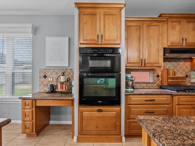 kitchen with tasteful backsplash, baseboards, under cabinet range hood, dark stone counters, and black appliances