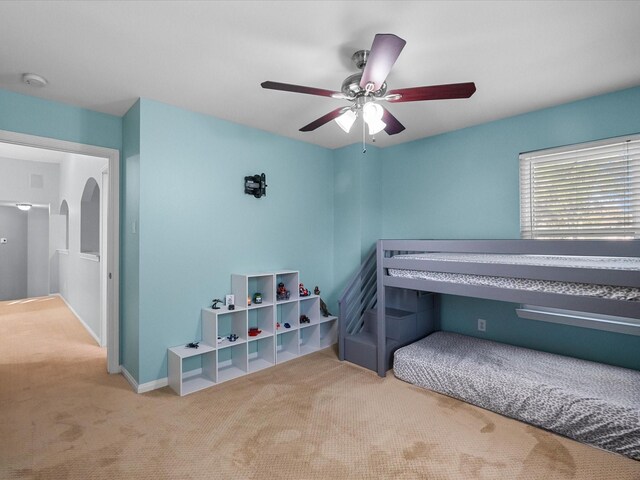 carpeted bedroom with baseboards and ceiling fan