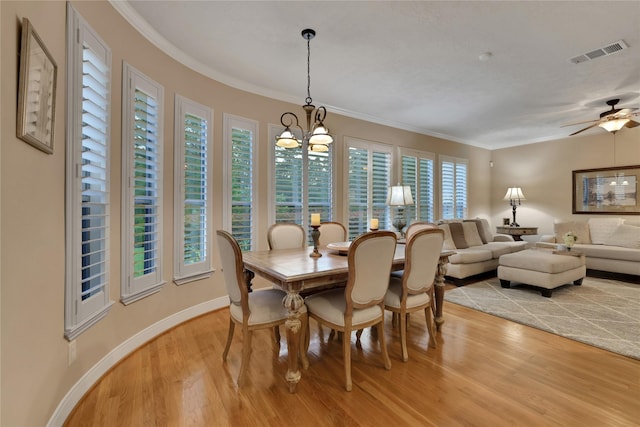 2814 S Cotswold Manor Dr, Kingwood, TX 77339 - dining space featuring visible vents, ornamental molding, ceiling fan with notable chandelier, light wood finished floors, and baseboards