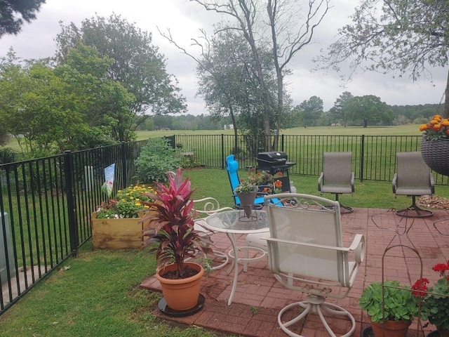 view of patio featuring a grill and fence