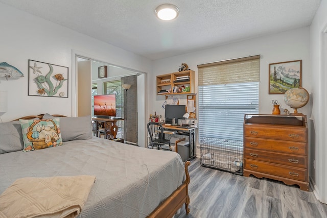 bedroom featuring wood finished floors and a textured ceiling