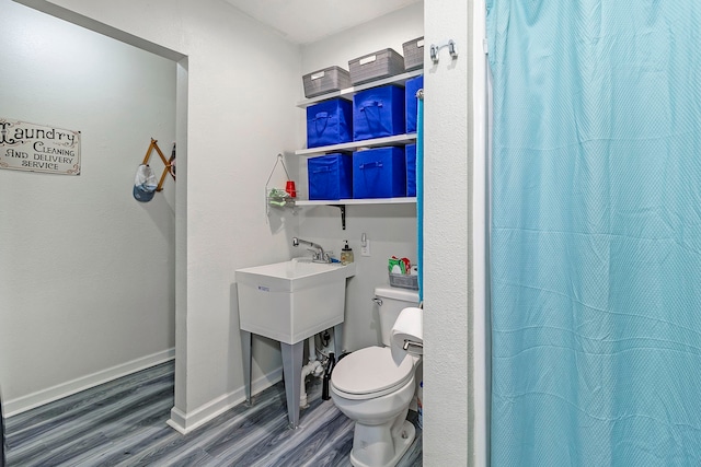 full bathroom with toilet, curtained shower, wood finished floors, and baseboards