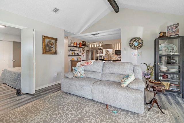 living area with lofted ceiling with beams, visible vents, wood finished floors, and baseboards