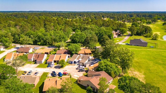 drone / aerial view with a residential view, view of golf course, and a wooded view