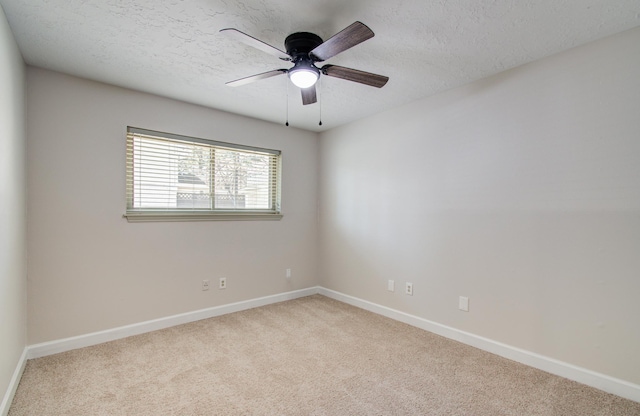 spare room featuring baseboards, carpet floors, a textured ceiling, and ceiling fan