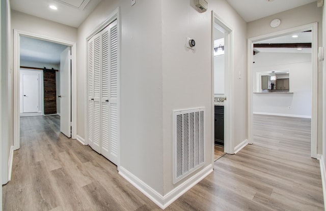 hall featuring recessed lighting, visible vents, light wood-style flooring, and baseboards