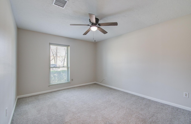 spare room featuring visible vents, a ceiling fan, a textured ceiling, carpet, and baseboards