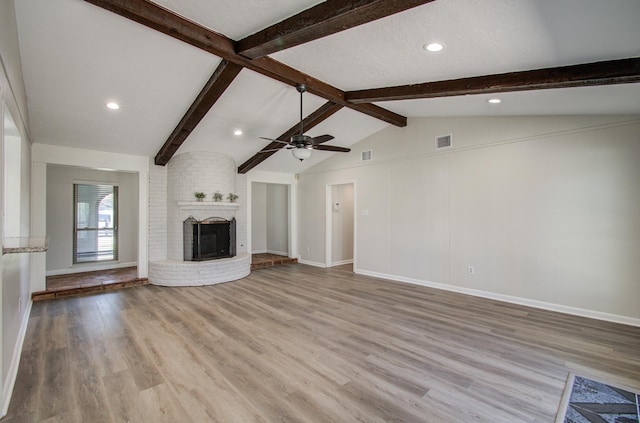 unfurnished living room with visible vents, vaulted ceiling with beams, light wood-style floors, and a ceiling fan