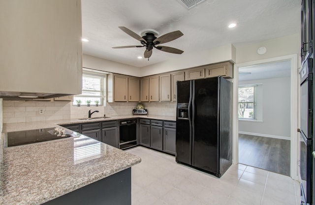 kitchen featuring visible vents, black appliances, a ceiling fan, a sink, and decorative backsplash