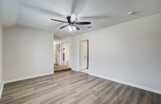 unfurnished room featuring baseboards, wood finished floors, a textured ceiling, and ceiling fan