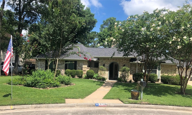 ranch-style house featuring a front yard, brick siding, and a shingled roof