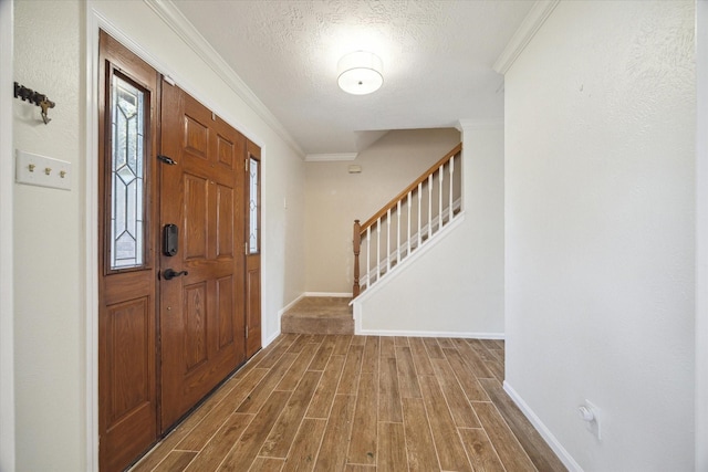 entryway with stairs, crown molding, wood finished floors, and a textured ceiling