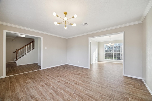 empty room with visible vents, light wood-style floors, an inviting chandelier, baseboards, and stairs