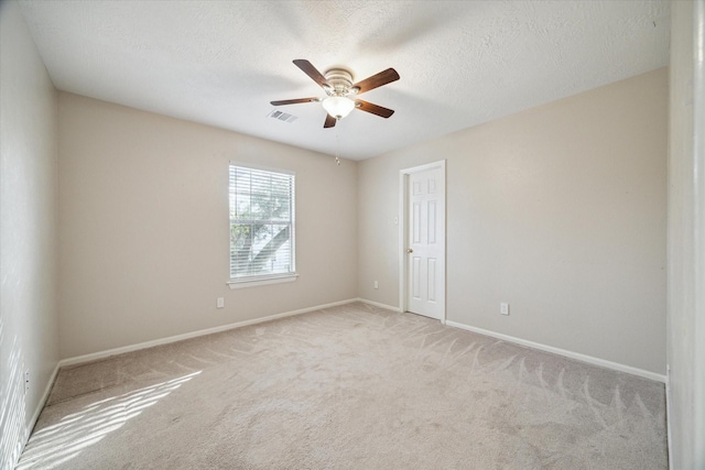 empty room featuring visible vents, baseboards, light colored carpet, and a ceiling fan