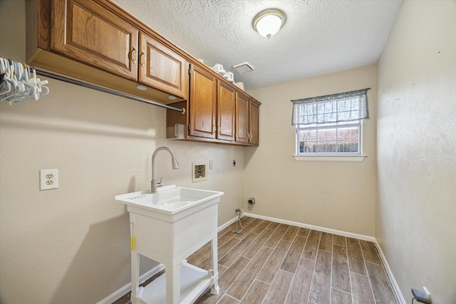 laundry area with hookup for a washing machine, wood finished floors, cabinet space, electric dryer hookup, and hookup for a gas dryer