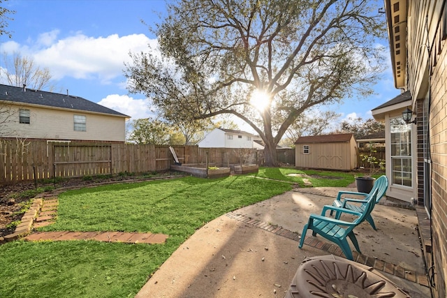 view of yard featuring an outbuilding, a vegetable garden, a fenced backyard, a storage shed, and a patio area