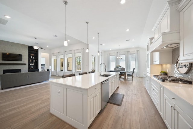 kitchen with a sink, stainless steel appliances, recessed lighting, and light wood finished floors