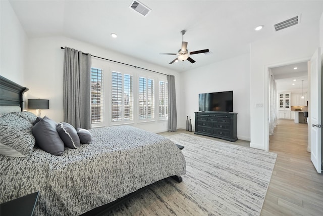 bedroom featuring visible vents, recessed lighting, light wood-style floors, and vaulted ceiling