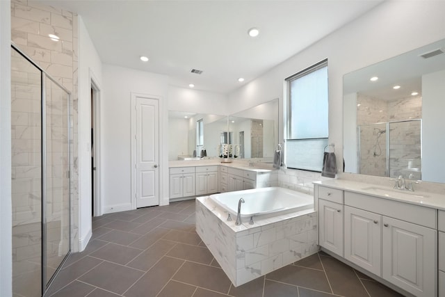 full bath with visible vents, two vanities, a stall shower, tile patterned flooring, and a bath