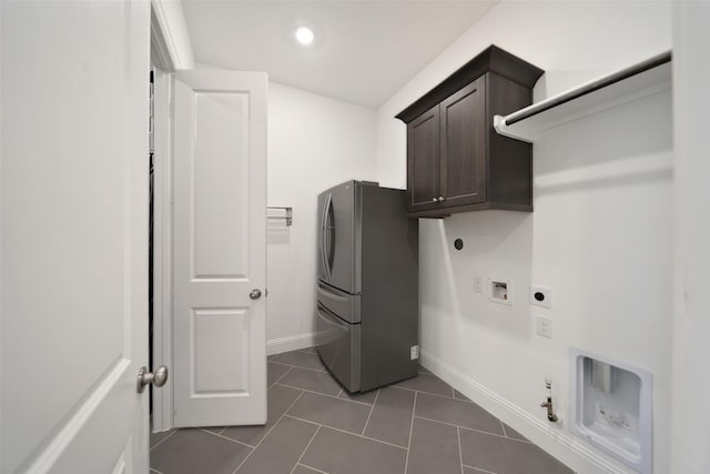 laundry room featuring baseboards, hookup for a gas dryer, cabinet space, electric dryer hookup, and dark tile patterned flooring