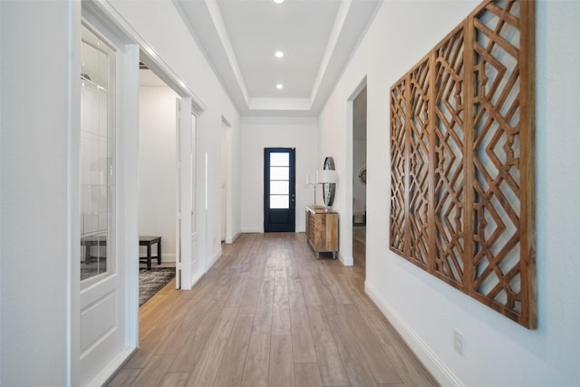 entryway featuring recessed lighting, a raised ceiling, light wood-type flooring, and baseboards