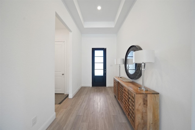 entryway with a raised ceiling, recessed lighting, baseboards, and light wood finished floors