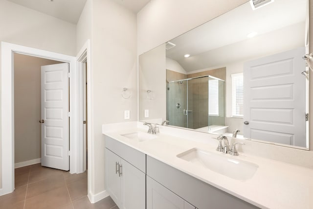 bathroom featuring tile patterned flooring, a stall shower, visible vents, and a sink