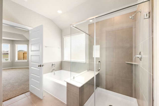 bathroom with lofted ceiling, a bath, a shower stall, and tile patterned flooring