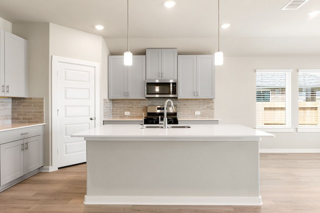 kitchen with light countertops, light wood-style floors, visible vents, and stainless steel appliances