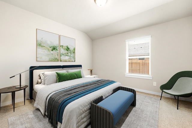 carpeted bedroom featuring lofted ceiling and baseboards