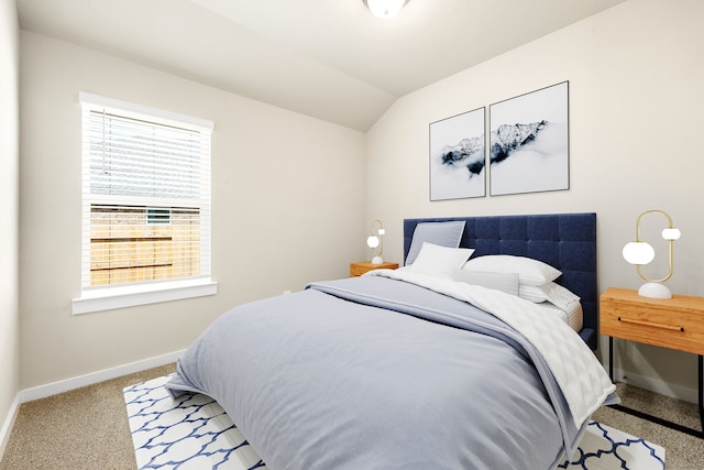 carpeted bedroom featuring baseboards and lofted ceiling