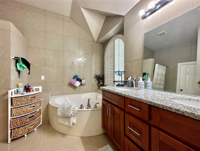 bathroom with visible vents, tile walls, and a bath