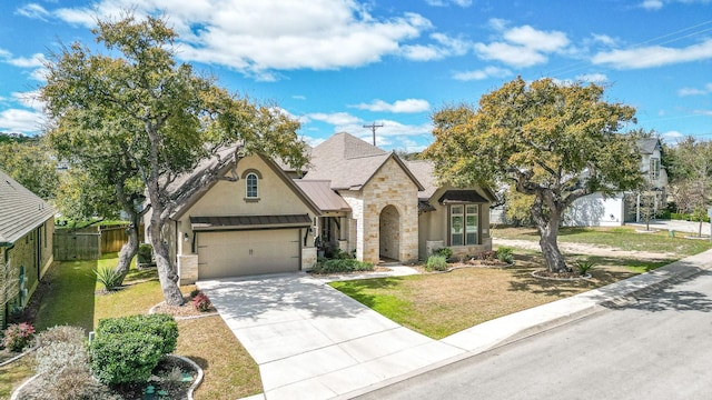 french country home with metal roof, stone siding, an attached garage, and a standing seam roof