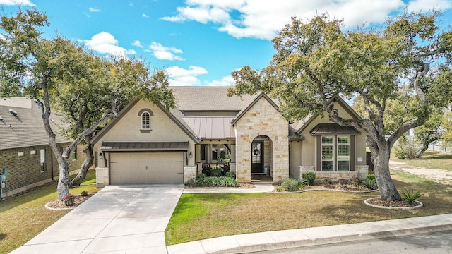 view of front of property featuring a front yard, metal roof, stone siding, driveway, and a standing seam roof