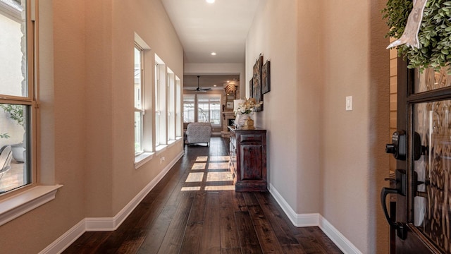 corridor with dark wood-type flooring and baseboards