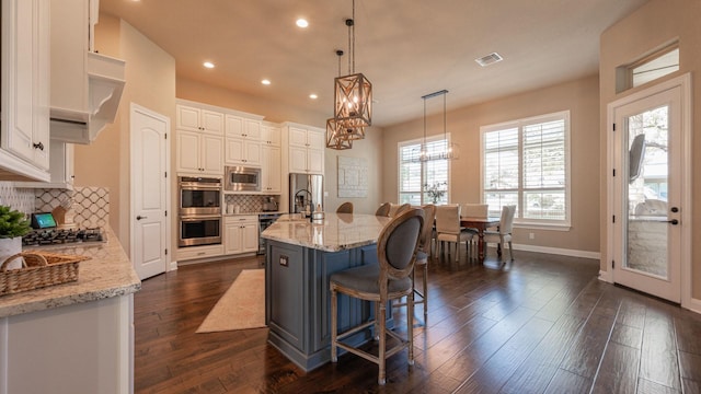 kitchen featuring dark wood-style floors, visible vents, an inviting chandelier, stainless steel appliances, and white cabinetry