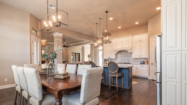 dining area featuring a chandelier, visible vents, baseboards, and dark wood-style floors