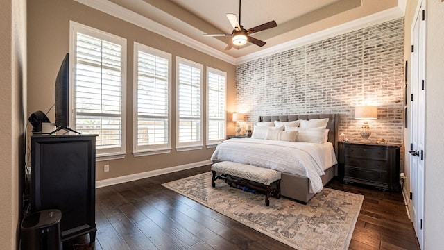 bedroom with dark wood-style floors, a raised ceiling, and ornamental molding