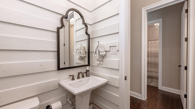 bathroom featuring a sink, baseboards, and wood finished floors