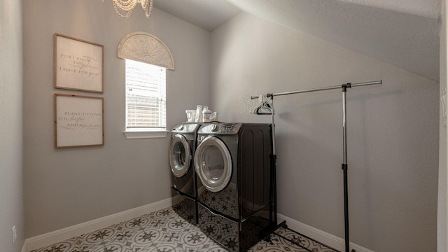 laundry area featuring baseboards, washer and clothes dryer, light tile patterned floors, laundry area, and an inviting chandelier