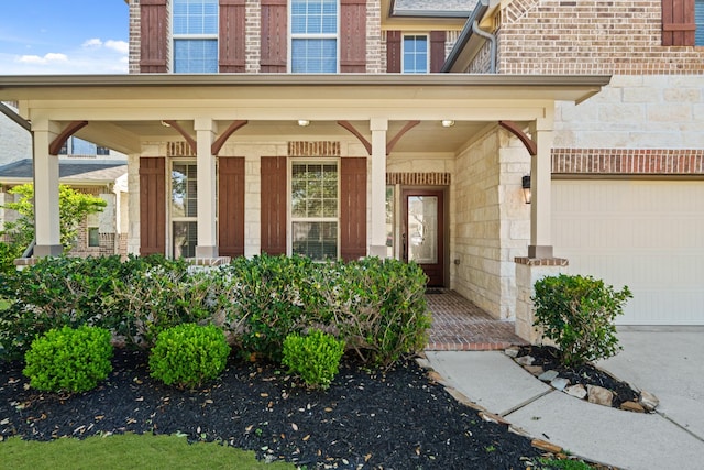 view of exterior entry with stone siding, brick siding, and covered porch