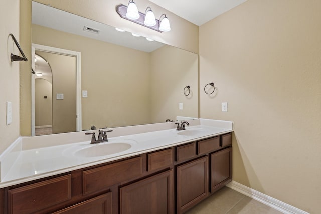 bathroom with tile patterned flooring, double vanity, visible vents, and a sink